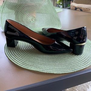 Black patent pump. 1-12" heels with gold insert.